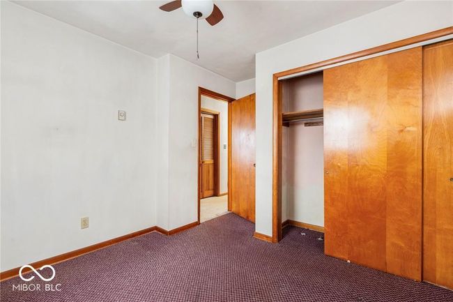 unfurnished bedroom featuring carpet floors, a closet, and a ceiling fan | Image 25