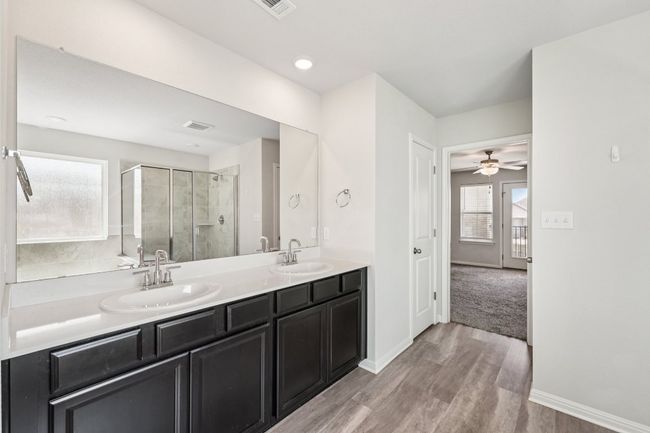 Bathroom with a shower stall, double vanity, wood finished floors, and baseboards | Image 13