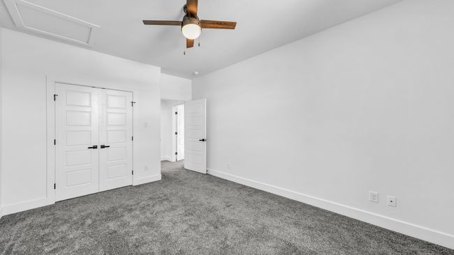 Unfurnished bedroom featuring baseboards, carpet floors, attic access, ceiling fan, and a closet | Image 34