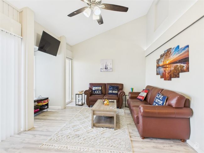 Living room featuring lofted ceiling, light wood flooring, ceiling fan. | Image 10
