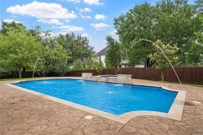 View of pool featuring a jacuzzi, a fenced in pool, a fenced backyard, and a patio area | Image 37