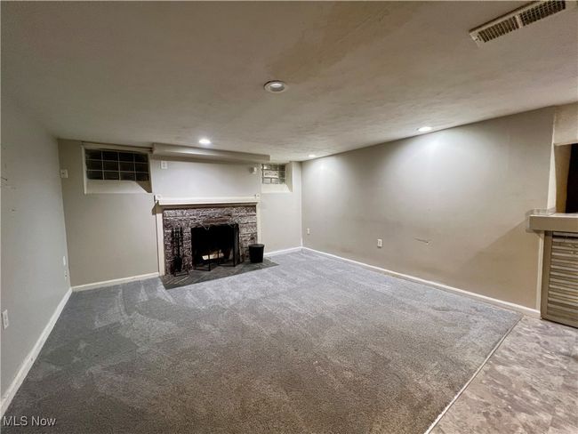 Basement featuring carpet flooring and a stone fireplace | Image 20