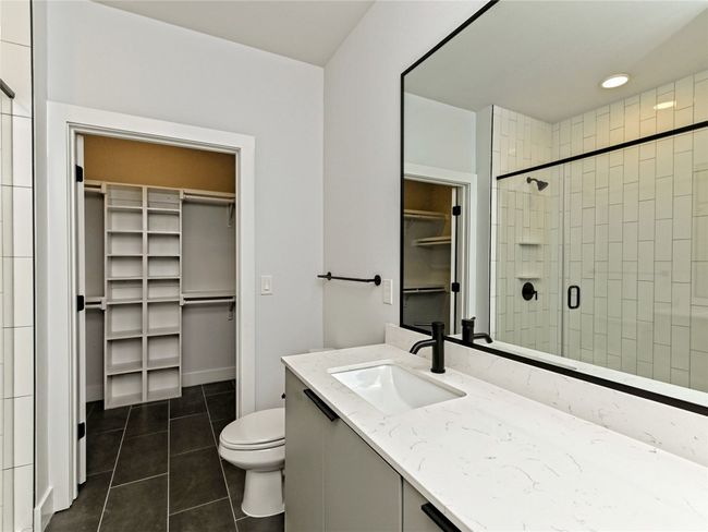 Bathroom with a spacious closet, tile patterned floors, vanity, a stall shower, and toilet | Image 7