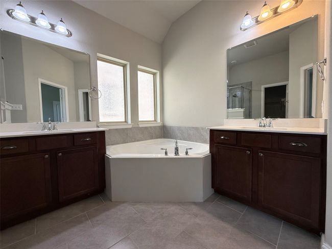 Full bathroom with a bath, vanity, a stall shower, a spacious closet, and vaulted ceiling | Image 9