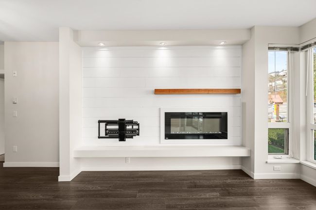 Detailed view of wood finished floors and a large fireplace | Image 16