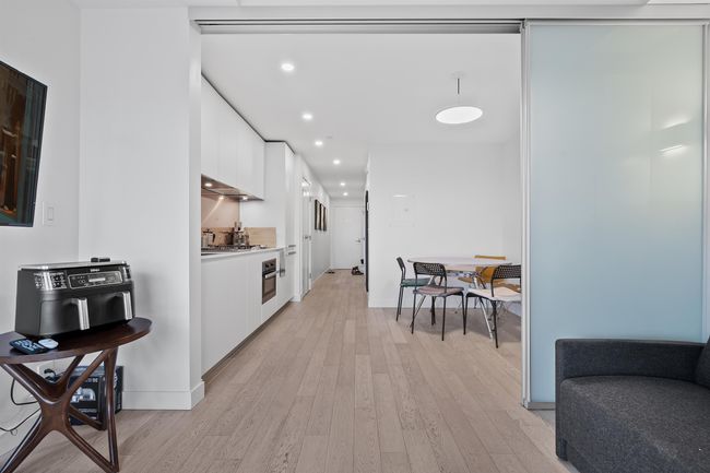 Kitchen featuring modern cabinets, white cabinetry, light wood-style floors, stainless steel oven, and recessed lighting | Image 4