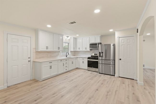Empty room with a ceiling fan, light wood-type flooring, baseboards, and recessed lighting | Image 19