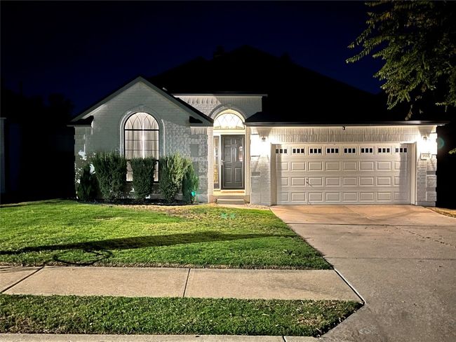 Single story home featuring an attached garage, driveway, a lawn, and brick siding | Image 29