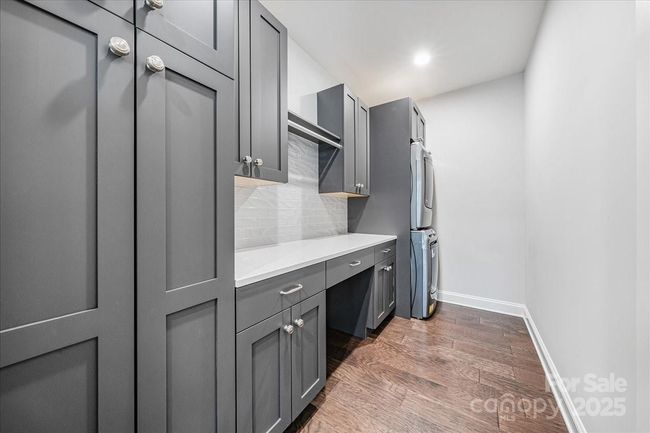 Laundry on main level with custom closet and storage system including a folding Quartz counter top, by Impact Fine Design | Image 21