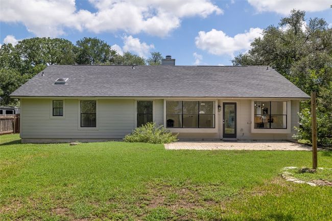 Rear view of the home highlighting the many windows and patio. | Image 28