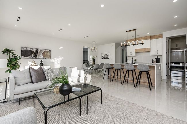 Living room featuring a chandelier, recessed lighting, and light marble finish floors | Image 10