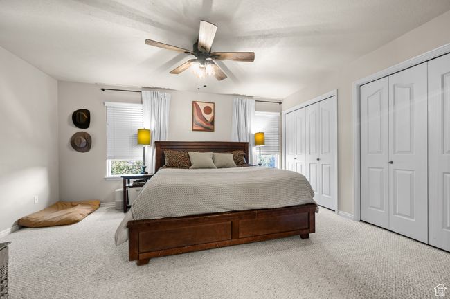 Bedroom with light colored carpet, multiple closets, and a ceiling fan | Image 17