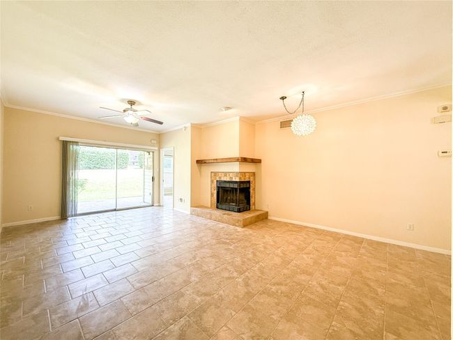 Unfurnished living room featuring crown molding, a tile fireplace, and ceiling fan | Image 23