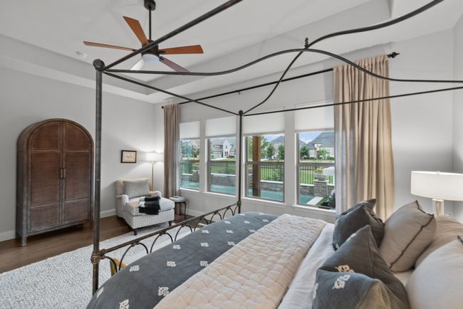 Primary bedroom with wall of windows, a tray ceiling, wood floors, and a ceiling fan | Image 20