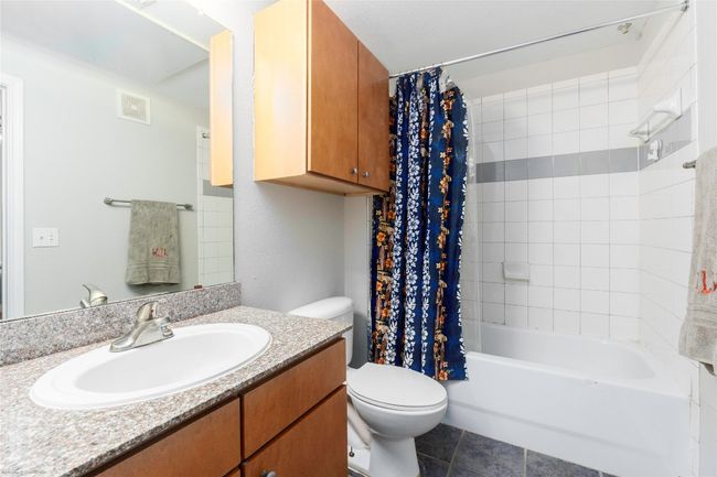 Bathroom with vanity, shower / bath combo with shower curtain, and tile patterned floors | Image 23