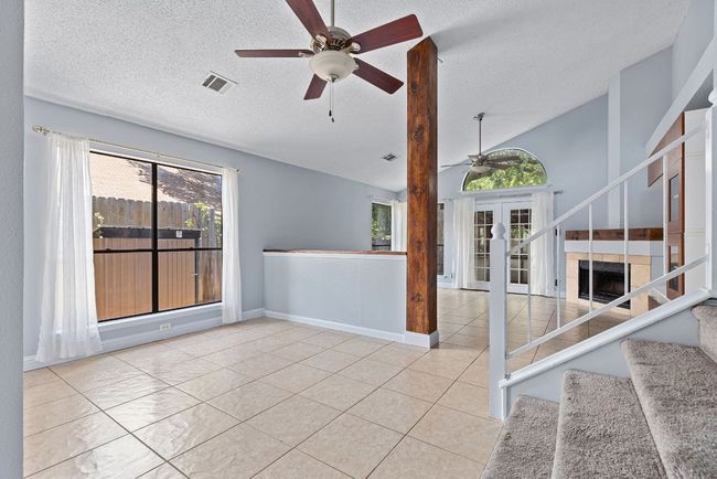 From this central point, everything flows. To your left, the living areas stretch out with high ceilings and openness, while the staircase invites you upward with a gentle curve and soft carpeting. | Image 6