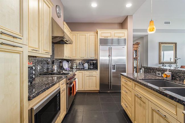 LIGHT WOOD CABINETS FOR THAT AIRY FEEL WITH CONTRASTING GRANITE COUNTERS AND BACK SPLASH | Image 9