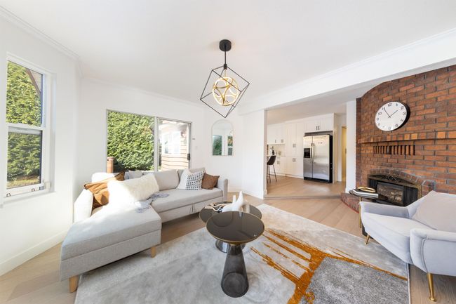 Living area with baseboards, light wood-type flooring, crown molding, and a fireplace | Image 17