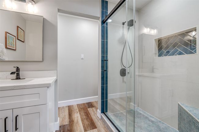 The en-suite bathroom features a spacious walk-in shower and modern sink vanity, offering both modern elegance and luxurious relaxation. | Image 12
