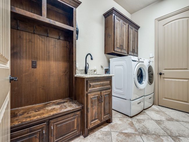 Washroom featuring cabinet space and washer and dryer | Image 20