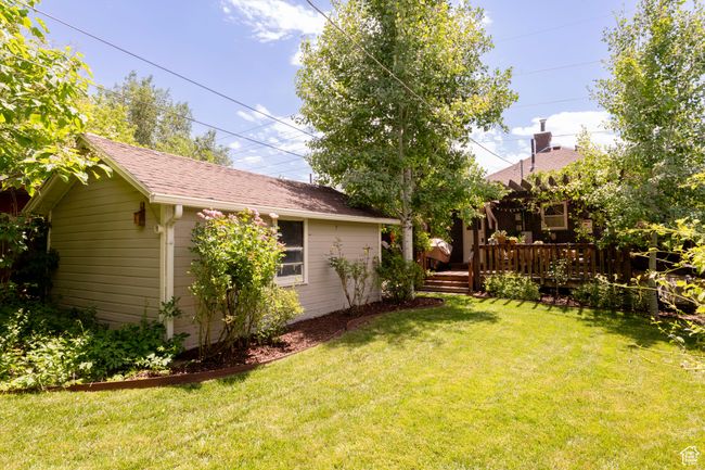 View of green lawn with a wooden deck and an outdoor structure | Image 29