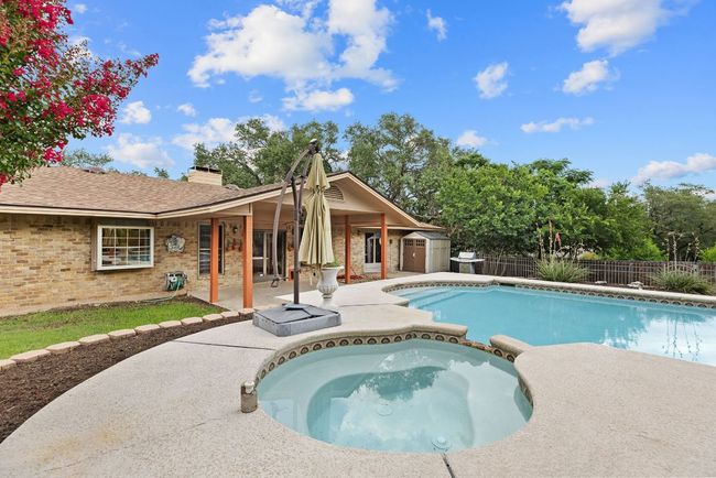 View of pool with a patio, a storage shed, a fenced backyard, and a pool with connected hot tub | Image 32