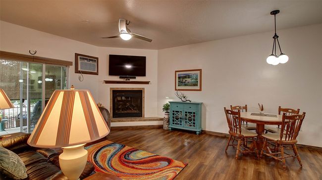 Spacious Living Room featuring LVP flooring, gas fireplace, tv wall mount, sliding door to patio, overhead ceiling fan, access to primary suite. | Image 19