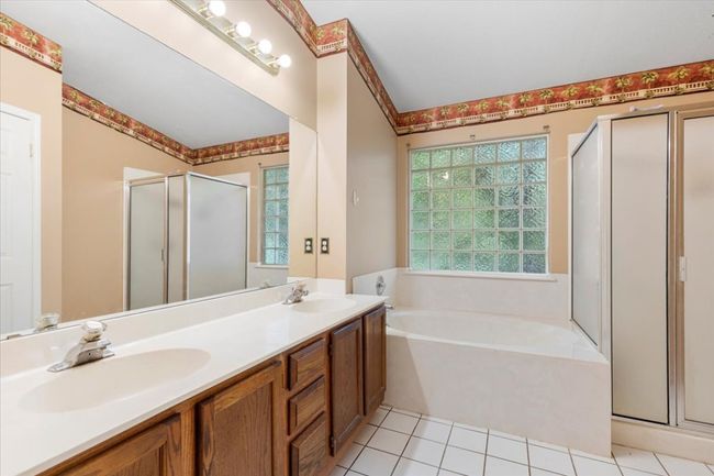 Full bath with a stall shower, a bath, plenty of natural light, and double vanity | Image 21