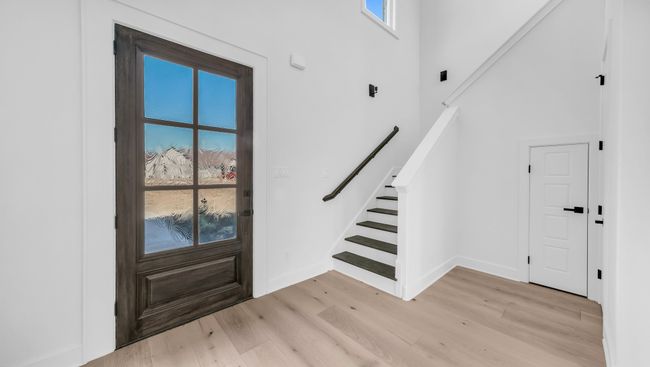 Foyer with stairway, a healthy amount of sunlight, light wood-style flooring, and a towering ceiling | Image 5