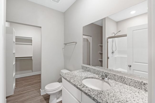 Bathroom featuring a stall shower, vanity, wood finished floors, toilet, and a spacious closet | Image 20