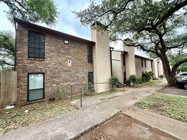 View of home's exterior featuring a chimney, brick siding, and fence | Image 20