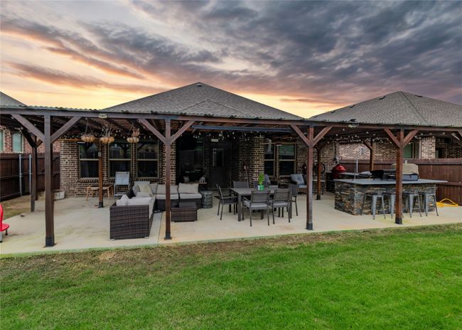 Fenced backyard with extended covered patio and large outdoor kitchen space | Image 15