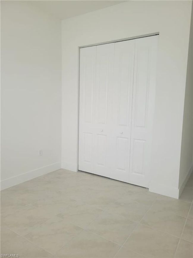 Unfurnished bedroom featuring baseboards, a closet, and light tile patterned flooring | Image 17