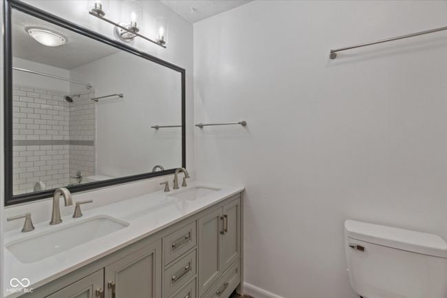 bathroom featuring double vanity and a textured ceiling | Image 15