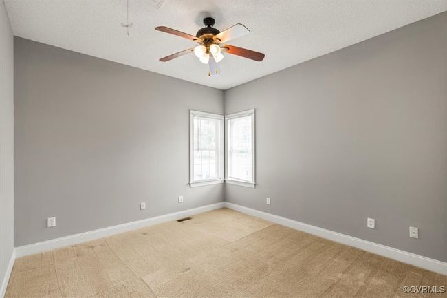 Unfurnished room featuring ceiling fan, baseboards, light colored carpet, and a textured ceiling | Image 33
