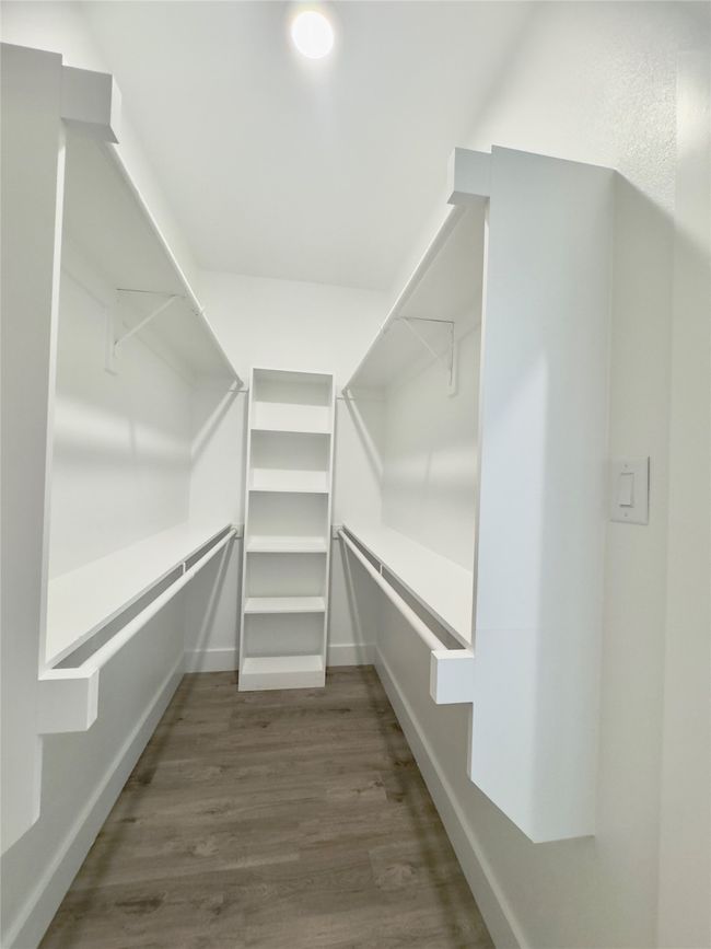 Walk in closet featuring dark wood-style floors | Image 16