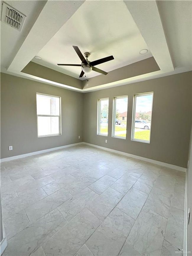 Empty room with a tray ceiling and ceiling fan | Image 7