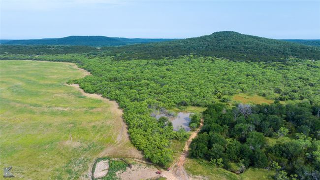 Aerial view of a heavily wooded area and a water and mountain view | Image 27