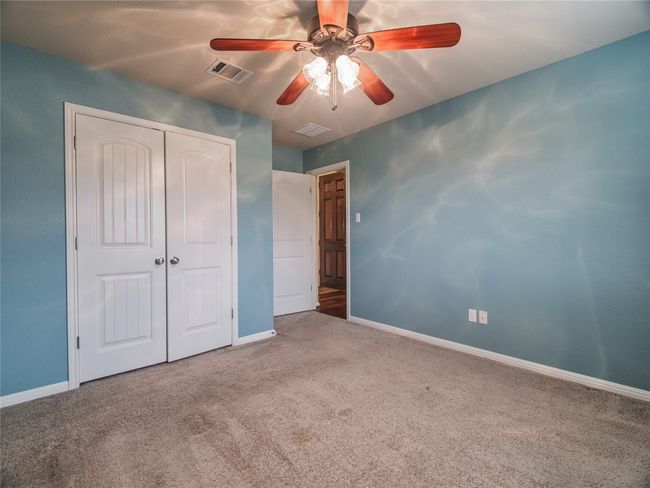 Unfurnished bedroom with carpet, baseboards, a closet, and a ceiling fan | Image 12