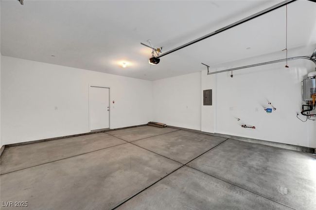 Garage featuring baseboards, a garage door opener, and electric panel | Image 28