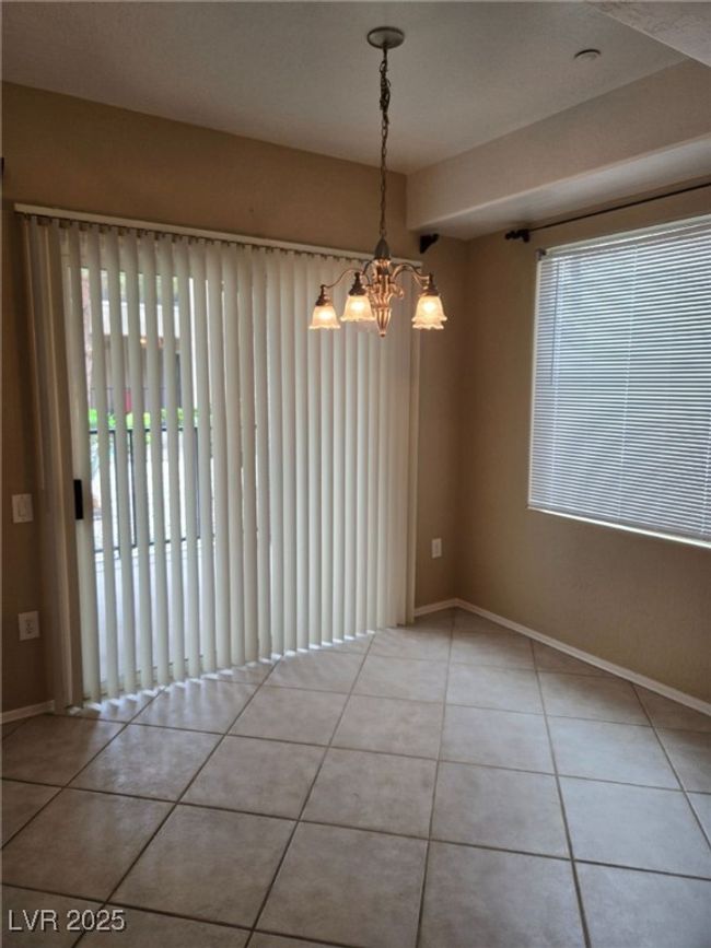 Spare room featuring tile patterned floors, an inviting chandelier, and baseboards | Image 12