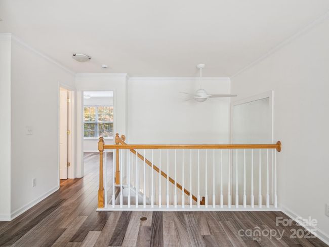 Upstairs loft is large with laminate flooring and crown molding. | Image 14