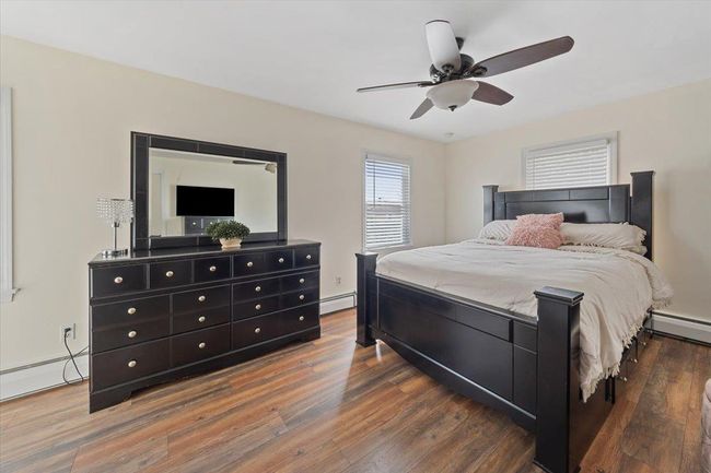 Bedroom with AC featuring ceiling fan, wood finished floors, and a baseboard radiator | Image 8