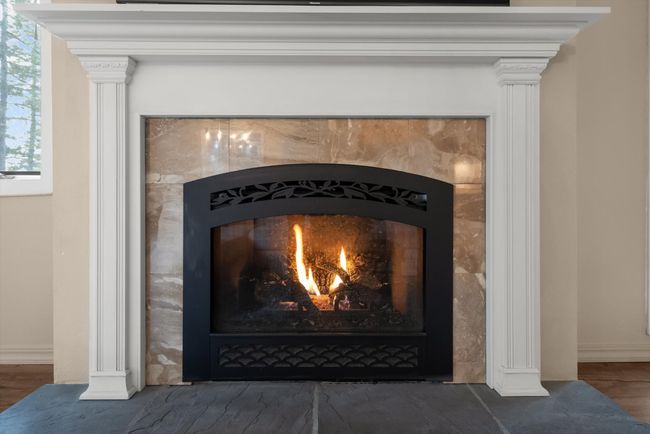 Detailed view of a fireplace, baseboards, and wood finished floors | Image 14