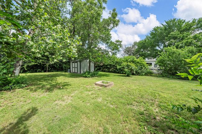 View of grassy yard featuring a storage unit | Image 20