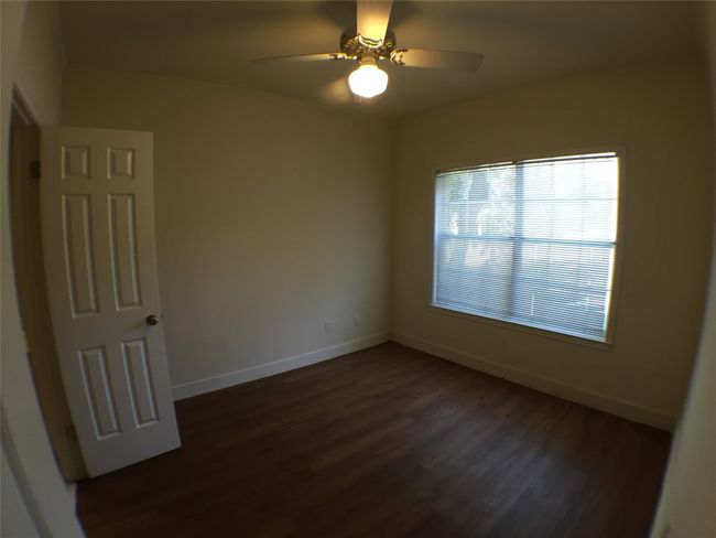 Unfurnished room with dark wood finished floors, a ceiling fan, and baseboards | Image 10