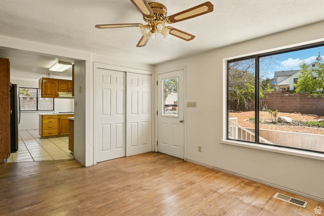 Unfurnished bedroom featuring freestanding refrigerator, light wood finished floors, ensuite bath, a closet, and a ceiling fan | Image 16