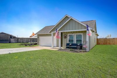 View of front of house featuring a garage, an outdoor hangout area, and a front yard | Image 1