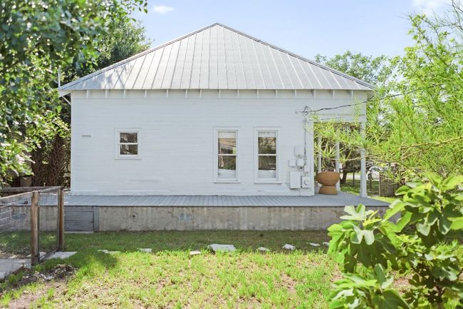 View of home's exterior featuring a wooden deck, metal roof, and a standing seam roof | Image 40