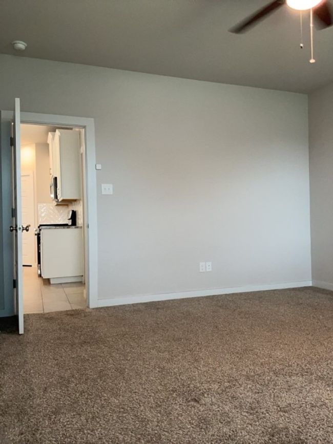 Primary room featuring light carpet, a ceiling fan, and a smoke detector | Image 16